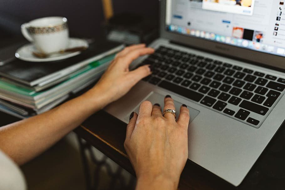 Hands typing on a laptop